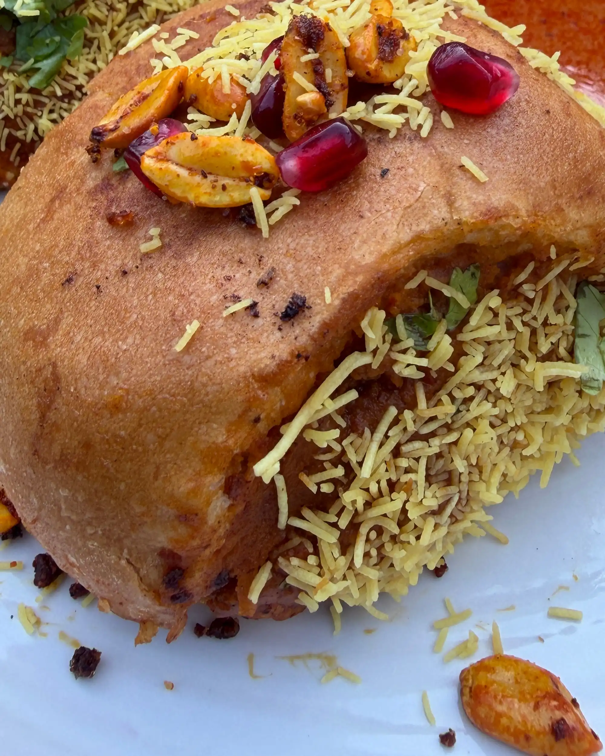Kutchi dabeli: a toasted pav packed with spiced potato, rolled in sev and topped with masala peanuts and pomegranate.
